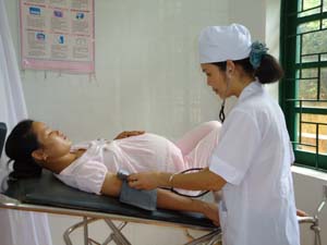 Cán bộ Trạm y tế xã Xuất Hóa (Lạc Sơn)  kiểm tra huyết áp cho phụ nữ mang thai.