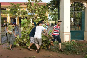 Học sinh Trường THCS Việt Trung (Quảng Bình) dọn vệ sinh trường lớp sau cơn bão số 10. Ảnh: NGỌC HẢI