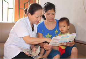 Cán bộ TYT thị trấn Lương Sơn tư vấn, phát tờ rơi cho các hộ gia đình trong khu vực có nguy cơ cao xảy ra dịch bệnh
