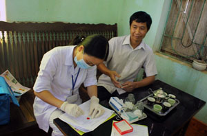 Y sỹ Bùi Thị Vui, Trạm trưởng Trạm Y tế xã Yên Phú (Lạc Sơn) lấy lam máu xét nghiệm tại hộ dân.