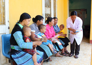 Cán bộ Trạm y tế xã Pà Cò (Mai Châu)  hướng dẫn các bà mẹ có con dưới 5 tuổi  thực hiện phòng, chống suy dinh dưỡng.
