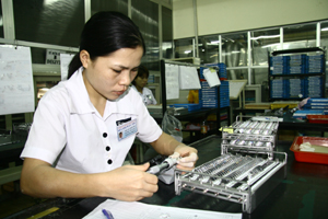 Trong khi nhiều dự án gặp khó khăn, doanh nghiệp đầu tư nước ngoài vẫn hoạt động có hiệu quả. Ảnh: Công nhân Công ty TNHH Nghiên cứu kỹ thuật R Việt Nam kiểm tra sản phẩm thấu kính trước khi xuất khẩu.