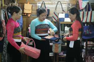Chị Vì Thị Oanh (đứng giữa) trao đổi với các thành viên trong HTX để đổi mới hình thức sản phẩm thổ cẩm.

