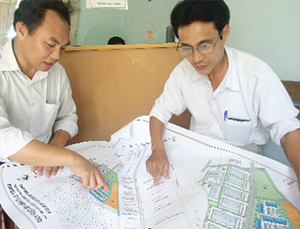 Lãnh đạo Công ty An Thịnh và ông Nguyễn Văn Lý, Trưởng xóm Hòa Vinh trao đổi về bản quy hoạch mới đem lại lợi ích cho người dân.