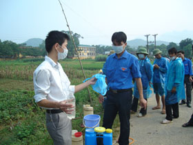 Cán bộ trạm bảo vệ thực hiện vật huyện Kim Bôi hướng dẫn kỹ thuật phun thuốc cho đội thanh niên xã Vĩnh Đồng.